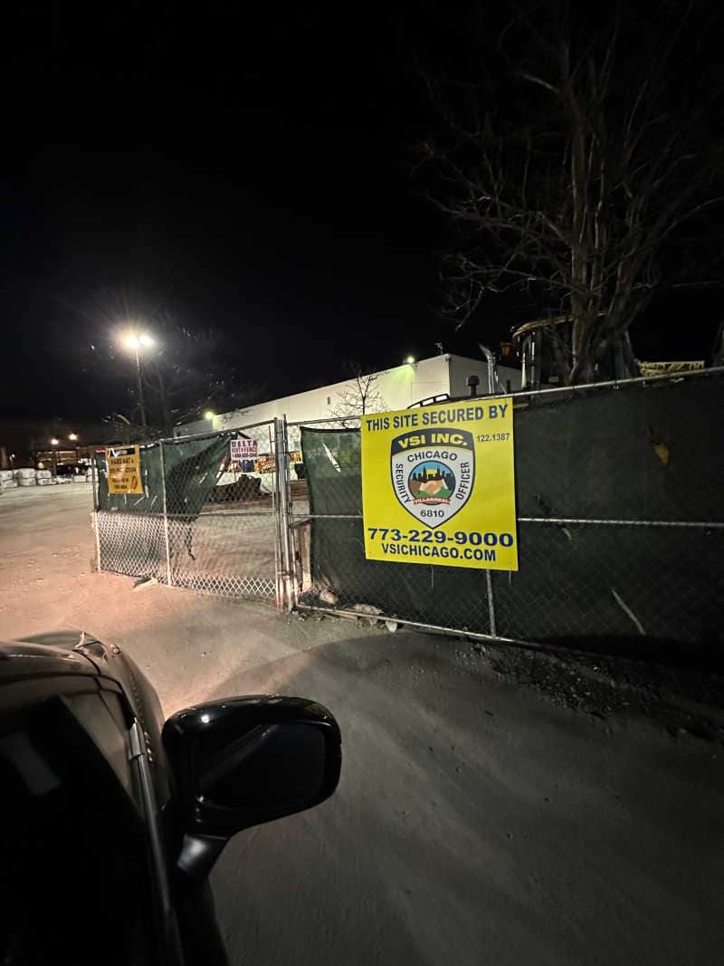 VSI Inc. Secured Construction Site – Protecting Assets Around the Clock A secured construction site at night with a VSI Inc. security sign displayed on the fence, emphasizing professional site protection and 24/7 monitoring to prevent unauthorized access and theft.